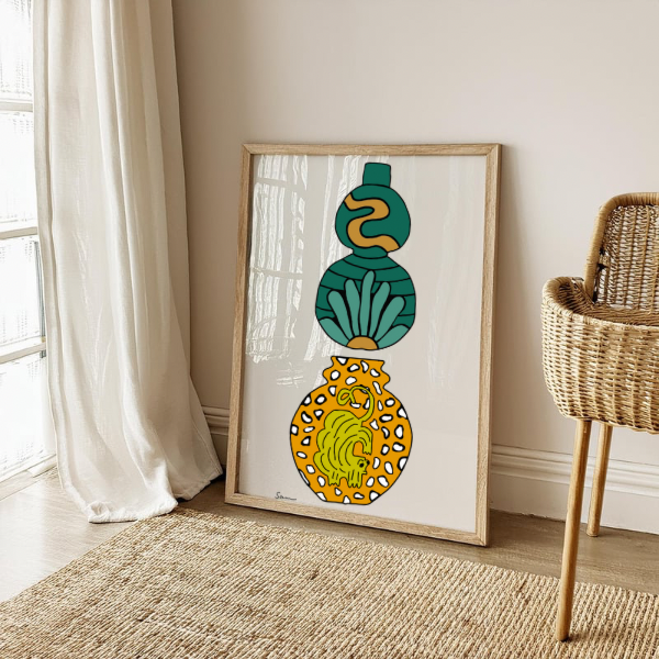 Framed modern art print featuring teal and mustard yellow abstract vases, displayed in a cozy, sunlit room with neutral decor.