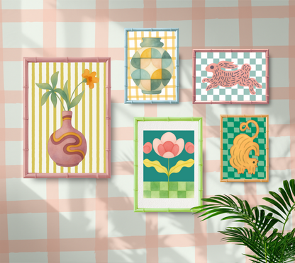 Set of colorful framed artworks on a checkered wall with plants.