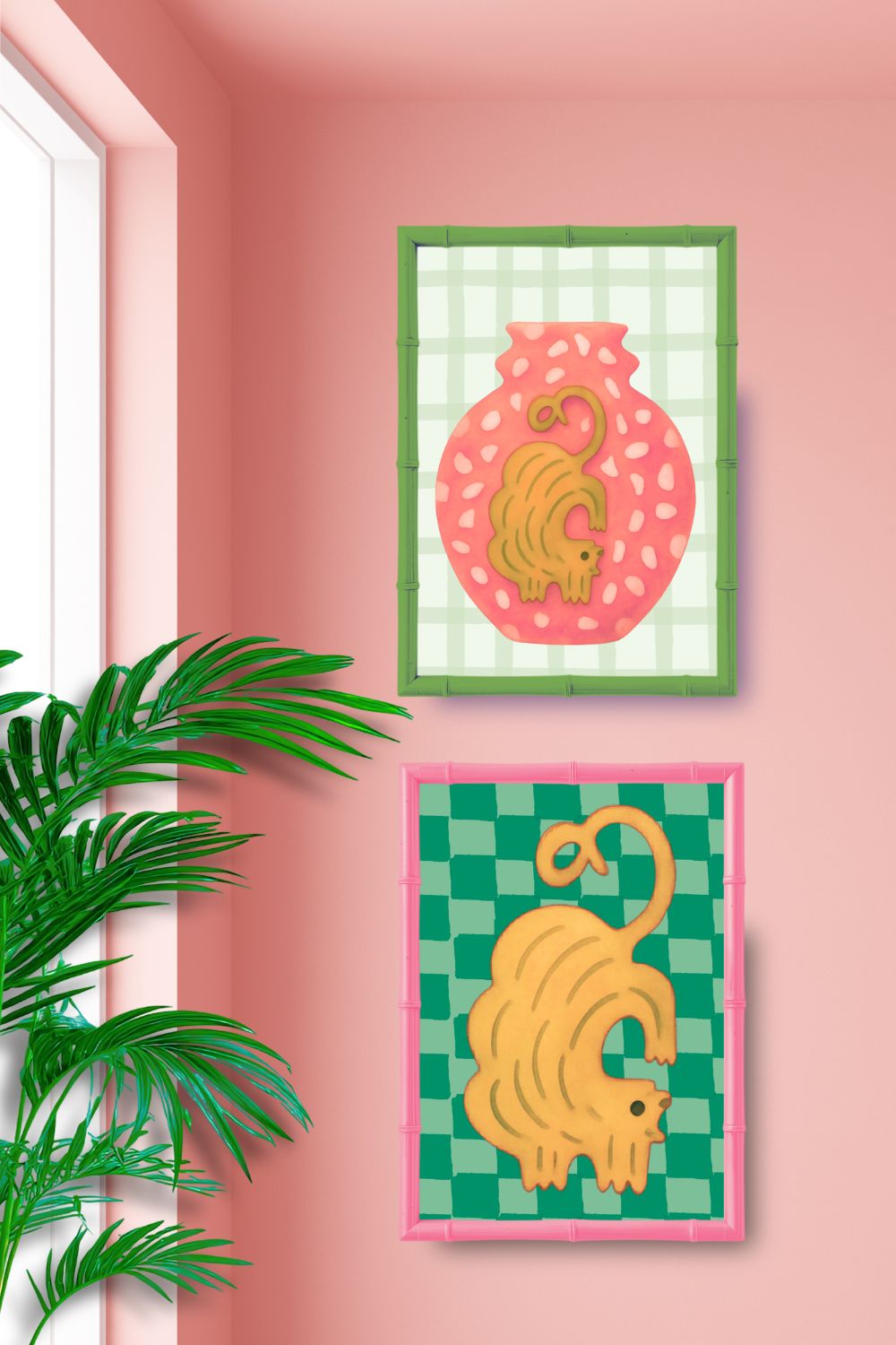 Two framed illustrations of a yellow cat on a pink wall with a plant in the foreground.
