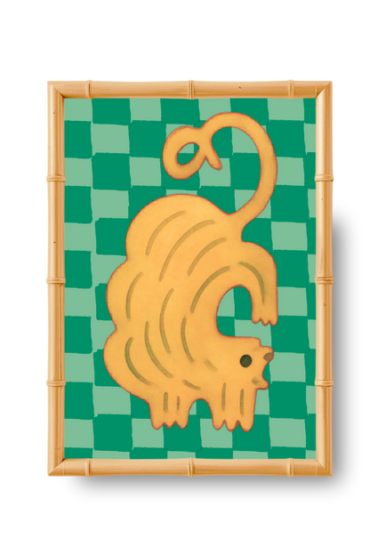 Decorative wall art with a yellow cat on a green checkered background, framed in bamboo.