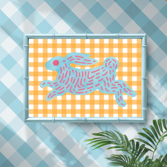 Framed artwork of a pink rabbit on a yellow checkered background, with a blue and white checkered pattern in the background.