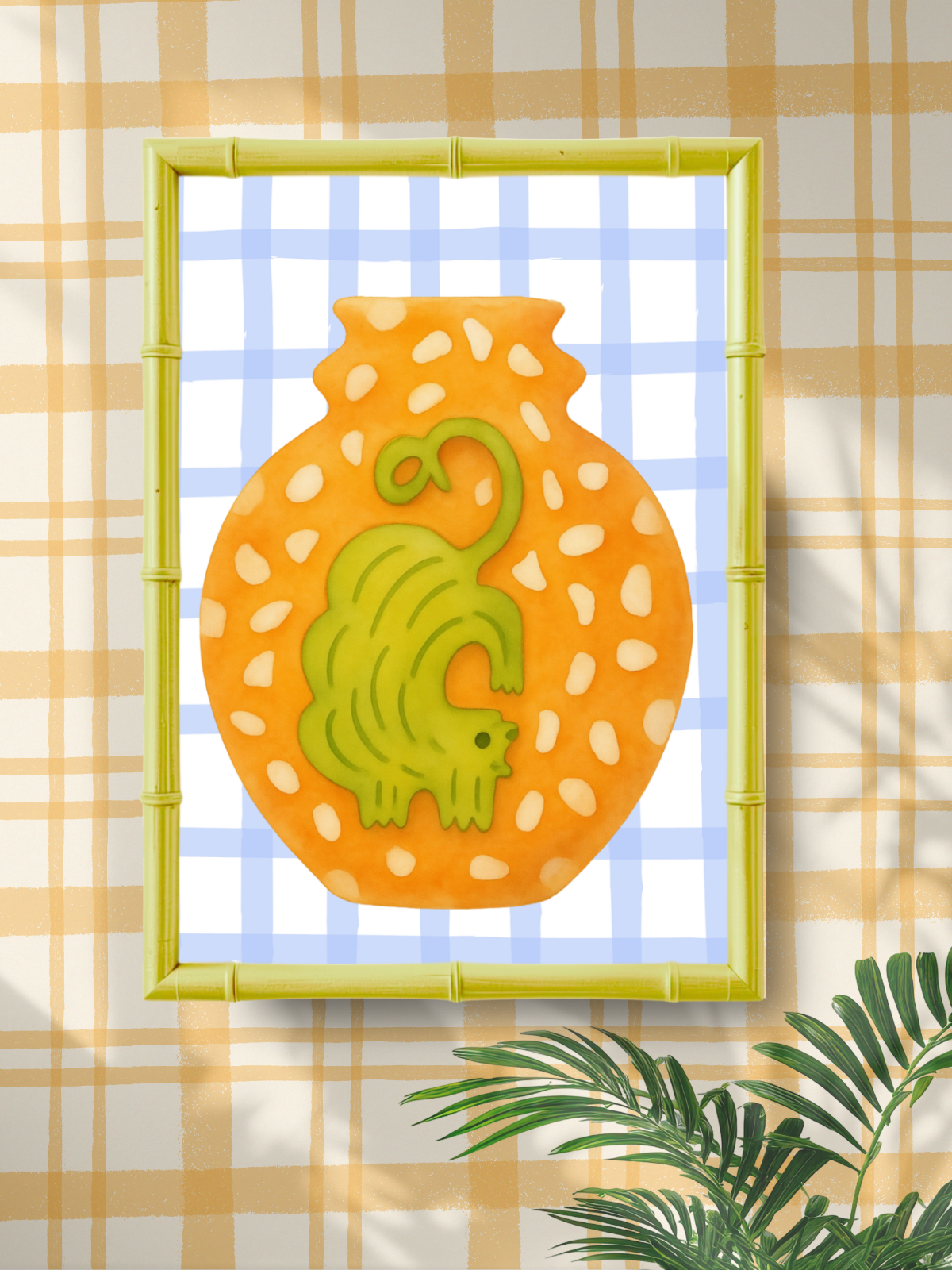 Decorative wall art with an ochre cat on an orange background, framed in bamboo, against a plaid wall.
