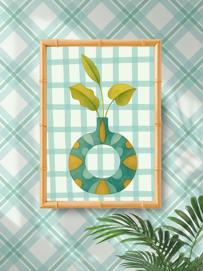 Framed artwork of a green vase with leaves on a checkered wall.